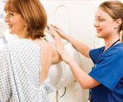 Technician with patient getting mammogram