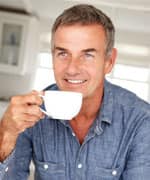 Mid age man with coffee at home