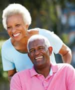 Senior Woman Pushing Husband In Wheelchair