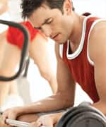 side view of a man working out with a barbell at the gym