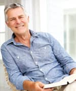 Senior man relaxing at home with a book