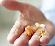 Senior man holding vitamin capsules