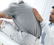 Man having back checked by doctor