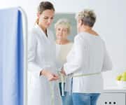 Woman being measured by doctor