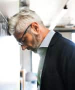 Man leaning head against a wall