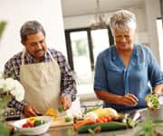 older latin couple preparing fresh vegetables