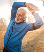 senior man stretching in a park before a job