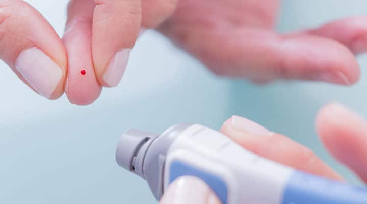 Doctor taking blood to test for optimal blood glucose levels