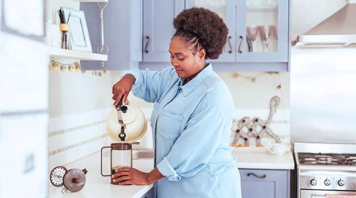 Woman pouring coffee for polyphenols and chlorogenic acid benefits
