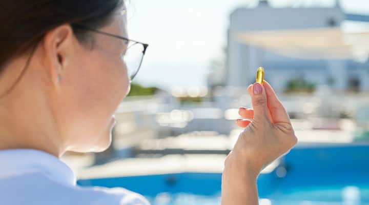 Woman taking omega-3 after meal for heart health