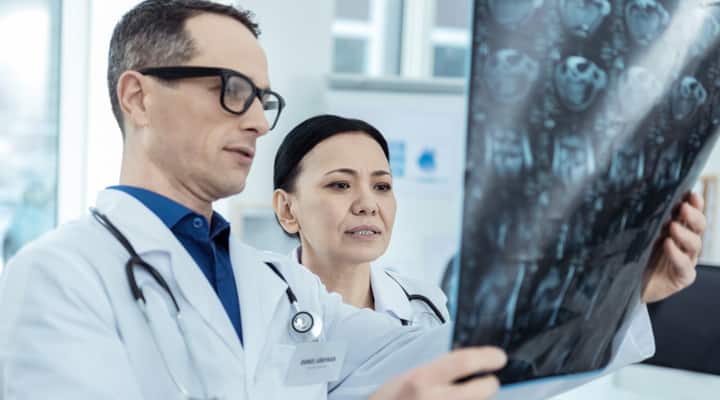 Pair of doctors examining brain scan for signs of Leukoaraiosis