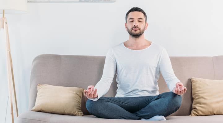 Man meditating on couch from recommendation from George Hamilton