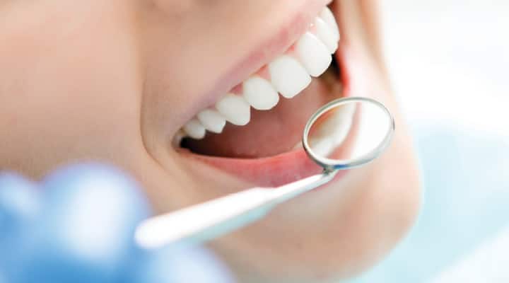 Dentist examining woman’s teeth after taking probiotics for a time
