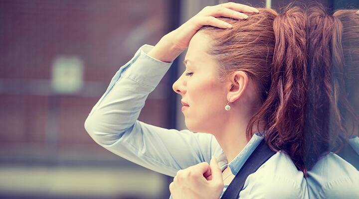 Woman clutching her head from difficulty coping due to her anxiety disorder