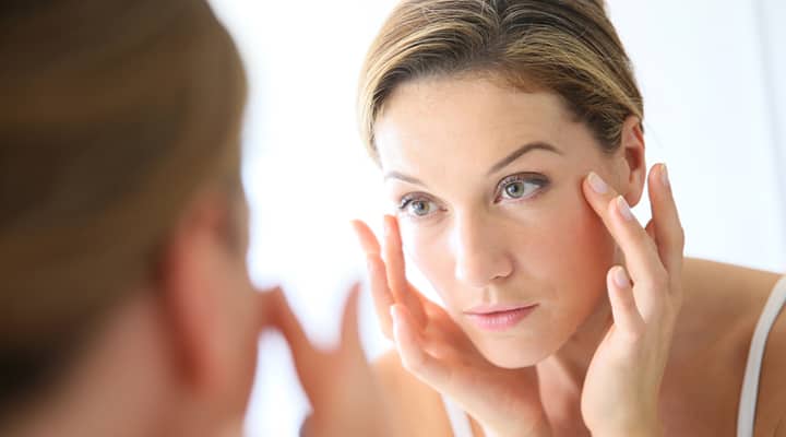 Woman washing her face for her skin and hair health