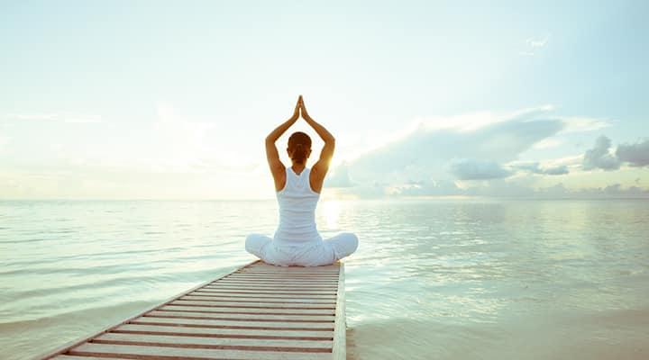 Woman sitting on a pier meditation for stress management