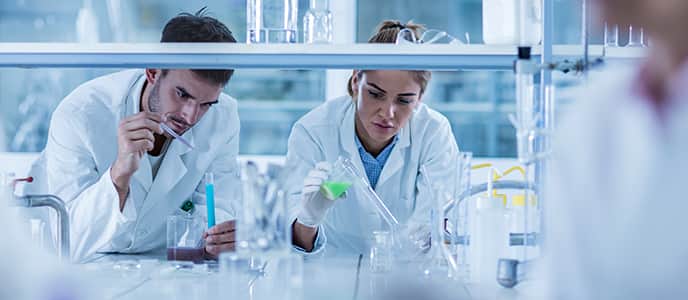 Scientists putting liquid in test tubes