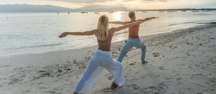 Couple doing yoga on beach