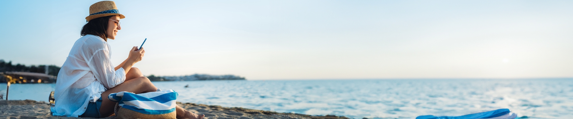 woman at the beach looking on her phone