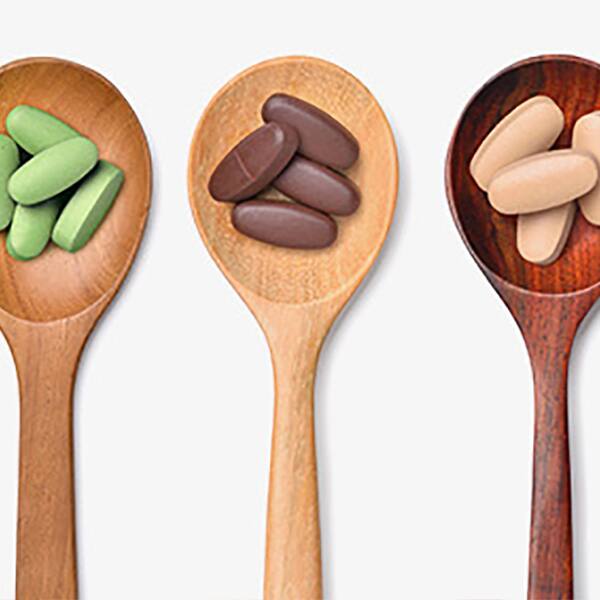 a variety of supplements in wooden spoons