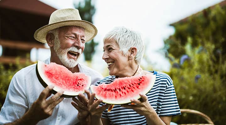 A happy couple eating watermelon