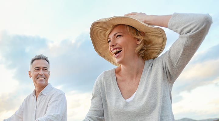 Laughing couple riding their bikes on a windy day