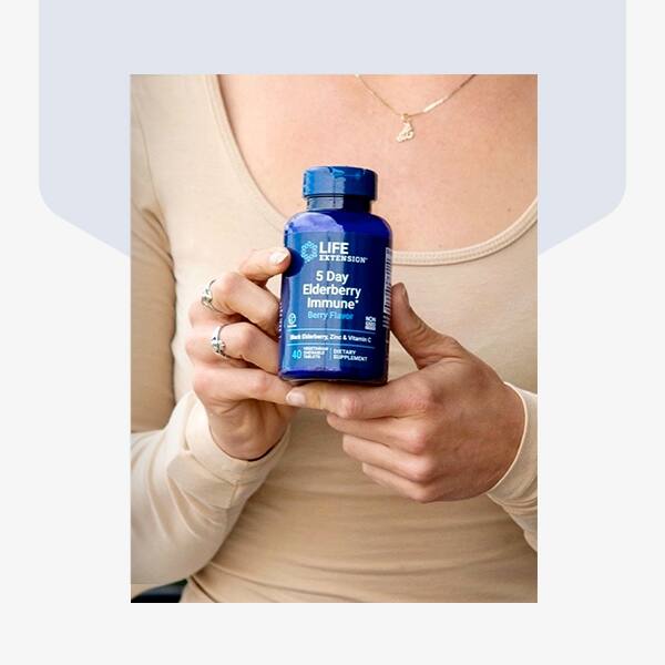 Hands holding a bottle of Life Extension Elderberry supplement.