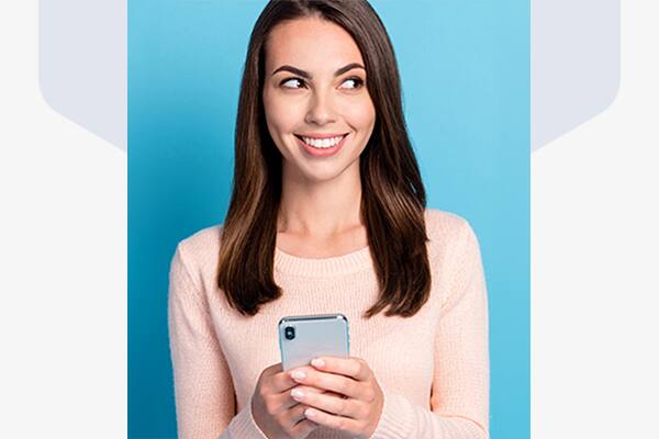 Young woman smiling while holding a smartphone
