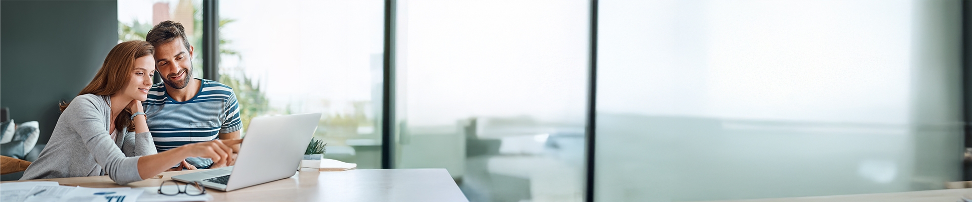 Young couple look at a laptop screen