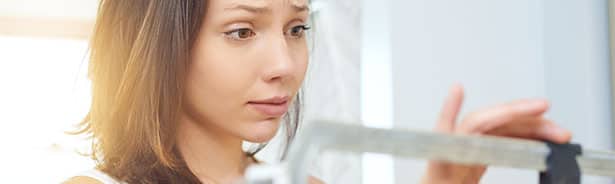 Woman weighing herself on scale