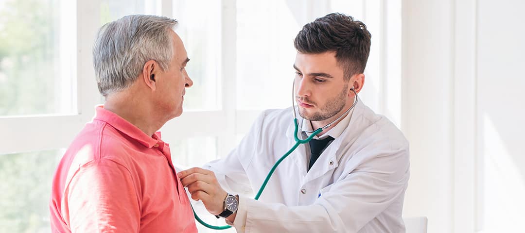 Doctor examining man's heartbeat