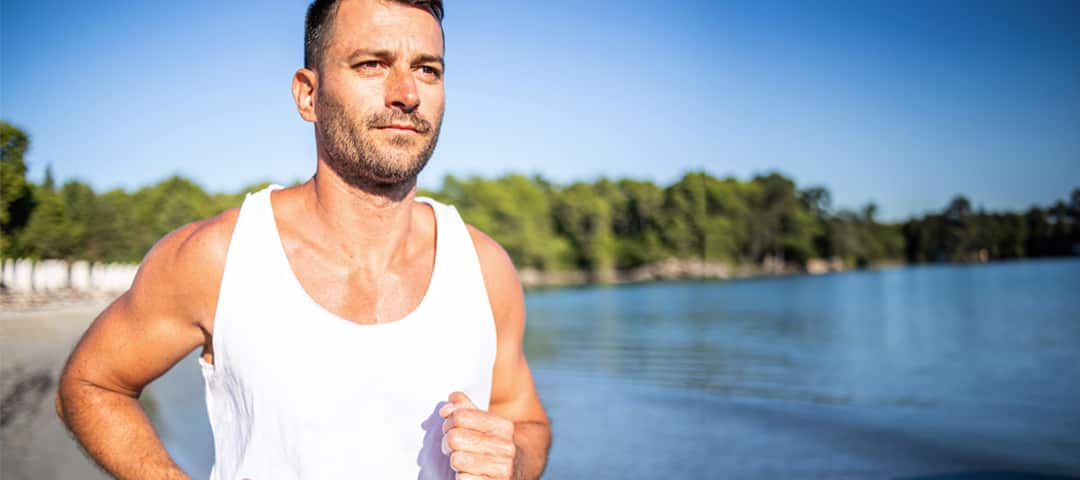 A man running on a beach early in the morning