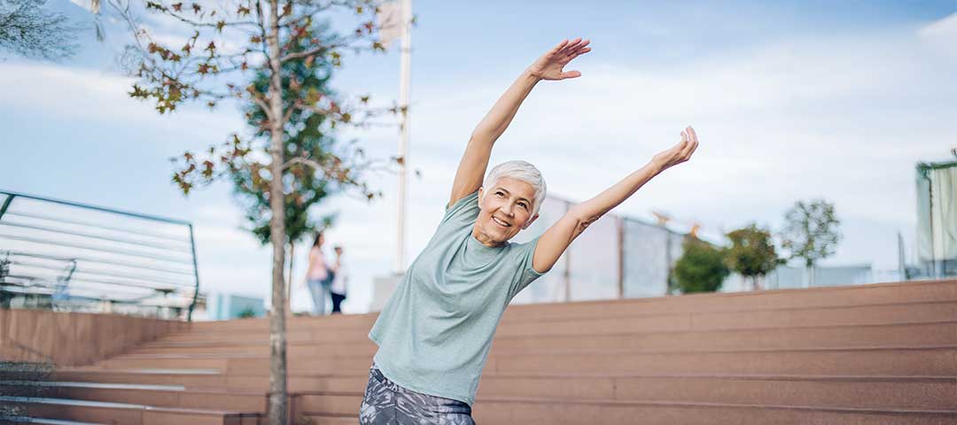 Happy senior woman exercising outdoors.