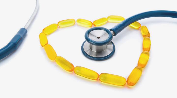 Fish oil in heart shape around stethoscope 