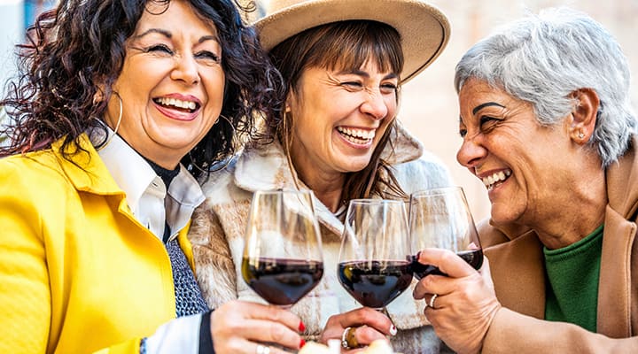 Healthy aging friends enjoying wine together