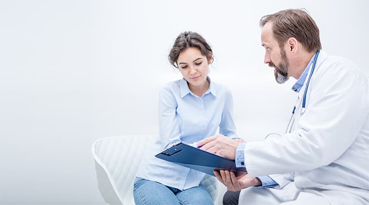 Doctor reviews lab results with young female patient