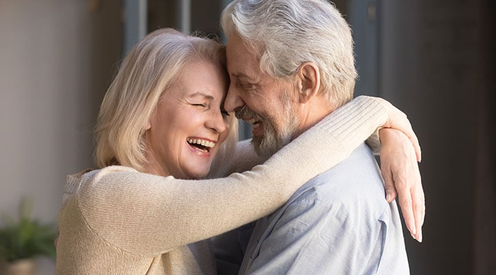 Older couple with healthy libido laughing and hugging