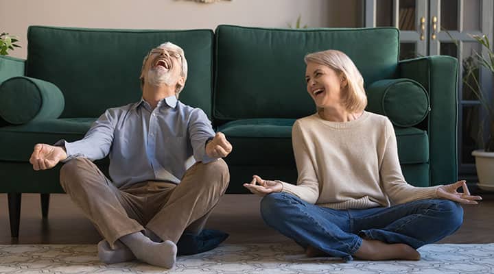 Couple laughing at each other while doing yoga