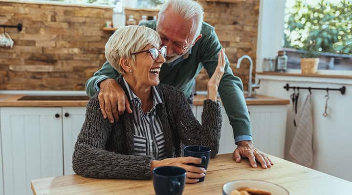 Senior couple laughing at table