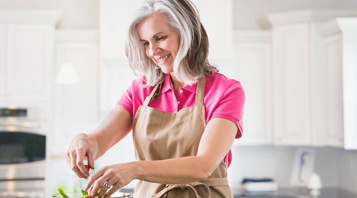 Middle-aged woman preparing a healthy salad at home