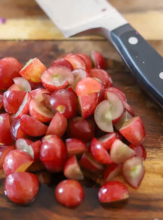 Quartered red grapes that are complemented well by adding pecans to salad