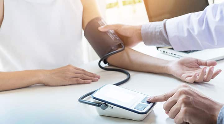 Woman having blood pressure taken for supplement recommendations