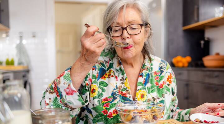 Active senior woman eating high fiber breakfast