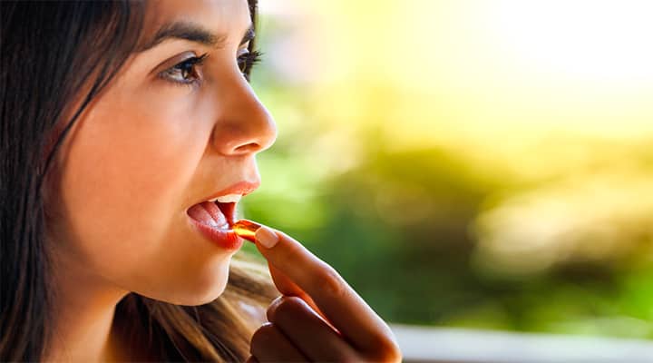 Woman taking vitamin D supplement for optimal whole-body health