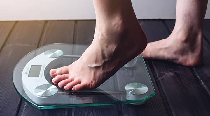 Man stepping on scale to check on his weight