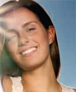Happy young woman under blue sky, portrait