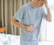 Man holding head and stomach