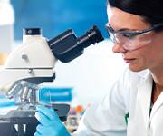 Scientist analyzing vaginal flora under a microscope