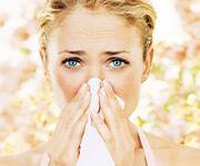 Woman with allergies blowing her nose